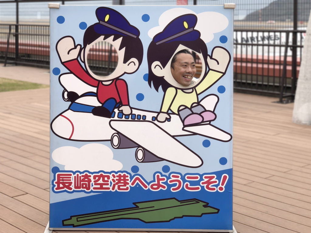 長崎の空の玄関口「長崎空港」の展望デッキで飛行機に乗る二人の顔ハメ